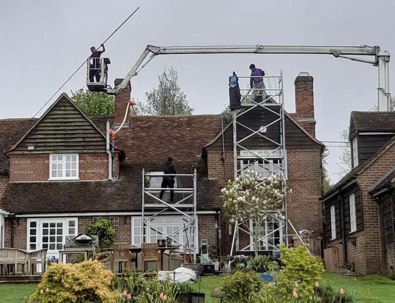 The Moss Cleaners using cherry picker and scaffolding to clean roof safely and professionally in West Clandon, Surrey